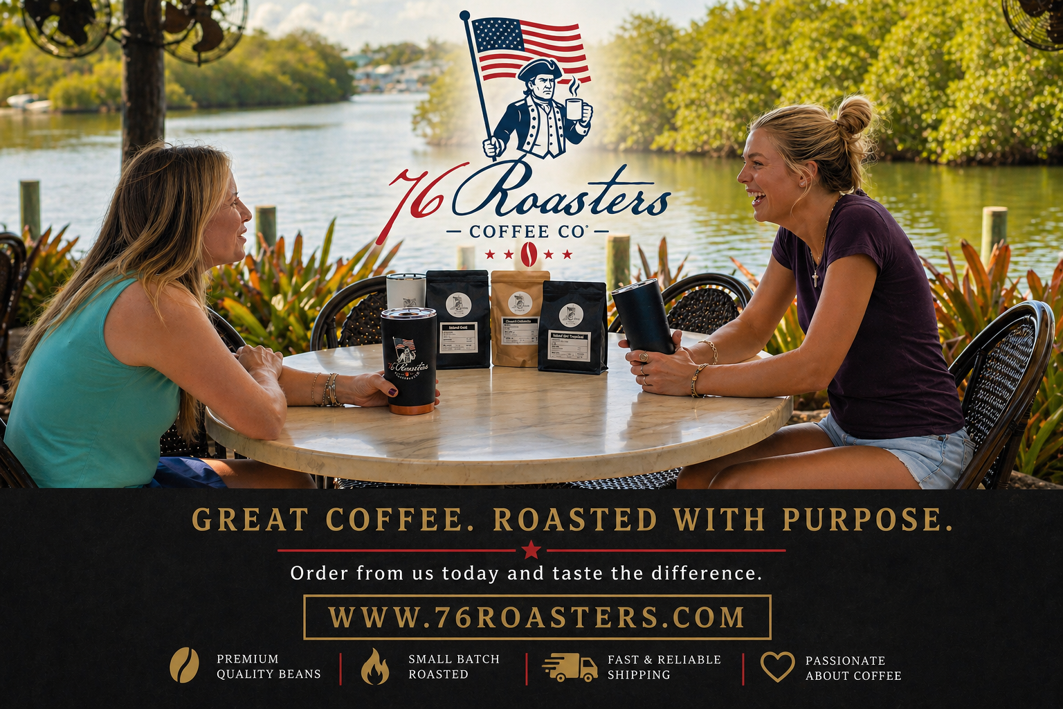 Two women chat at a round outdoor table by a river, with 76 Roasters Coffee branding and coffee bags on display behind them.