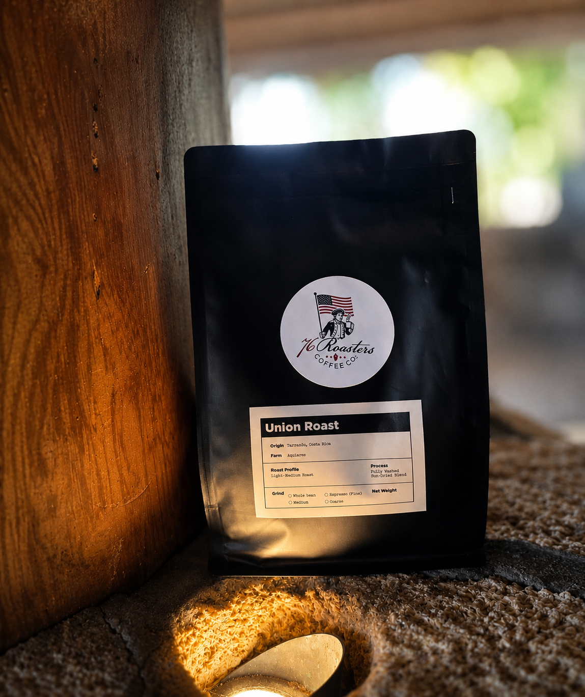 Black coffee bag labeled Union Roast from 76 Roasters Coffee Co., leaning against a wooden post with a circular logo on the front cover image.